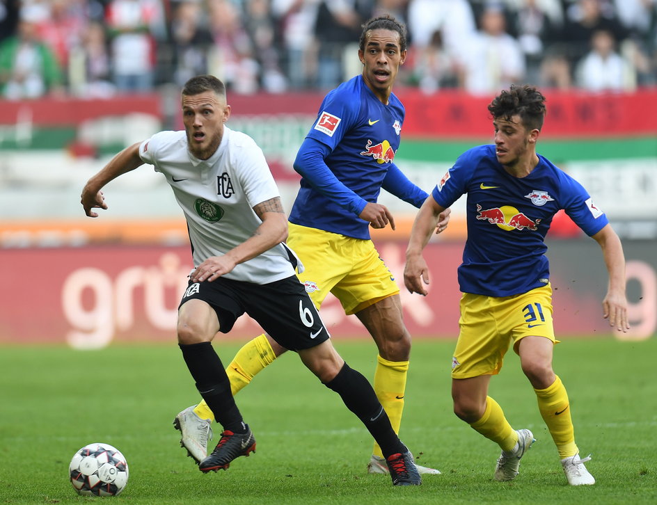 Yussuf Poulsen i Diego Demme w meczu z Augsburgiem. Obaj przeszli drogę od 3. Bundesligi do Ligi Mistrzów. Pierwszy z nich jest reprezentantem Danii, drugi łączy grę na boisku z tą na konsoli. Jest zawodnikiem sekcji e-sportowej RB Leipzig.