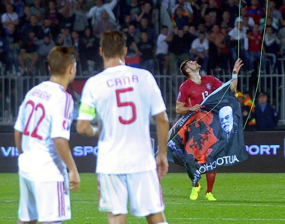 Serbski obrońca Stefan Mitrović chwyta albańską flagę, którą przyczepiono do drona, podczas meczu obu drużyn z 2014 roku 