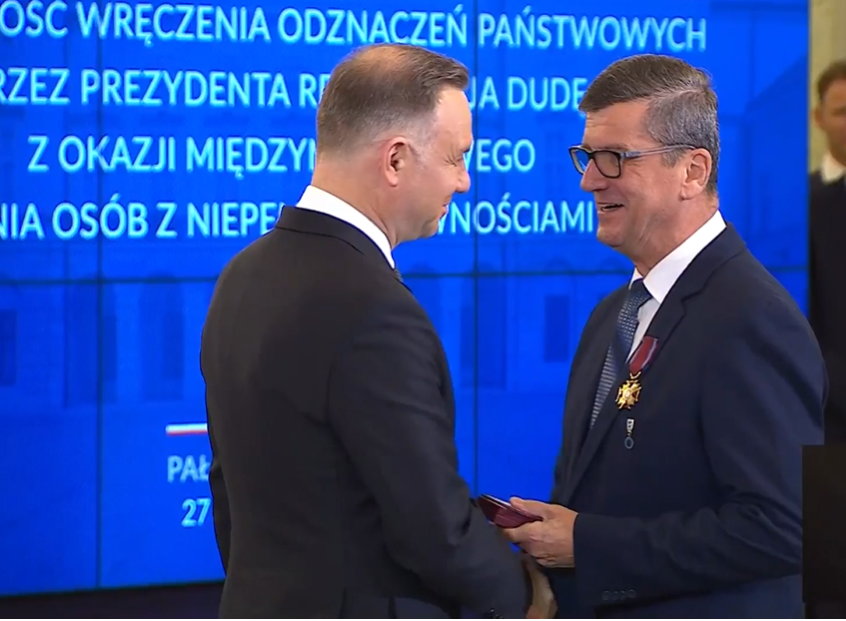 Janusz Bukowski odbierający gratulacje i Złoty Krzyż od Andrzeja Dudy w listopadzie 2023 r.