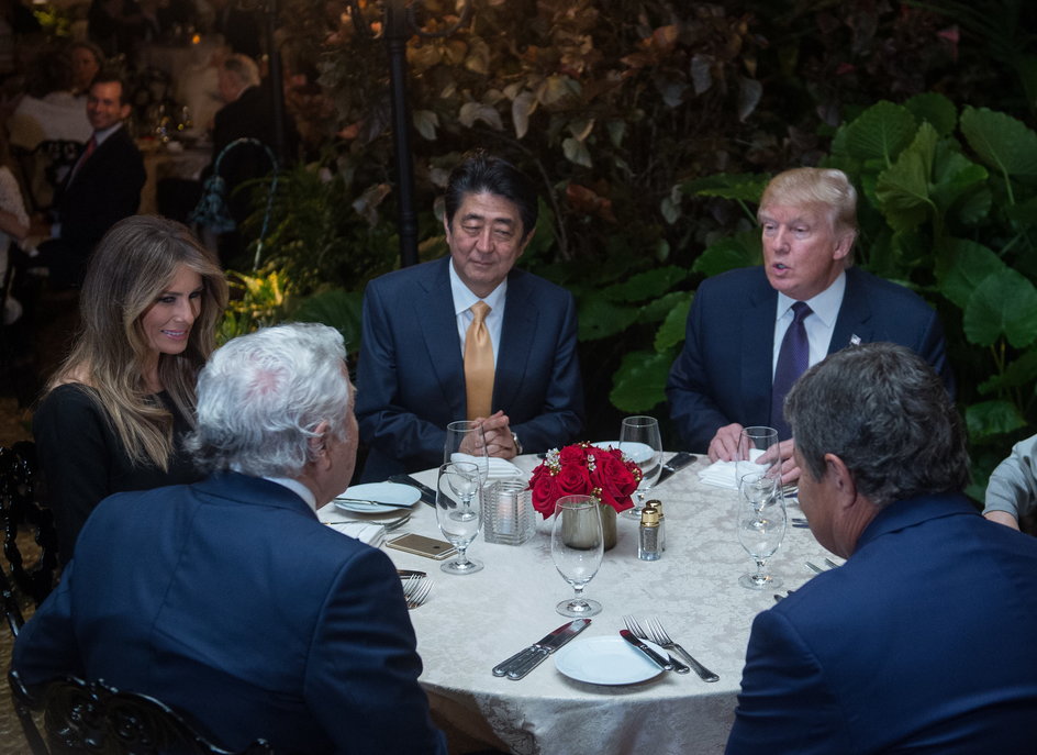 Od lewej, siedzą przodem: Melania Trump, Shinzo Abe, Donald Trump. Robert Kraft odwrócony plecami po lewej stronie