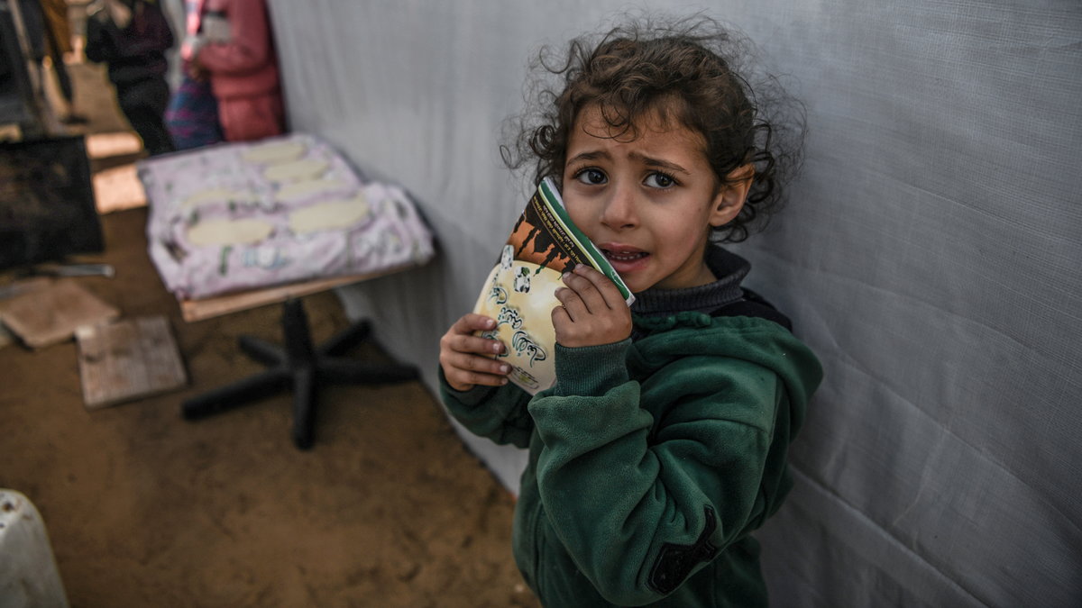 Namioty mieszkalne i młody Palestyńczyk w Strefie Gazy