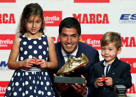 Barcelona's soccer player Luis Suarez poses with the Golden Boot trophy during a ceremony in Barcelona