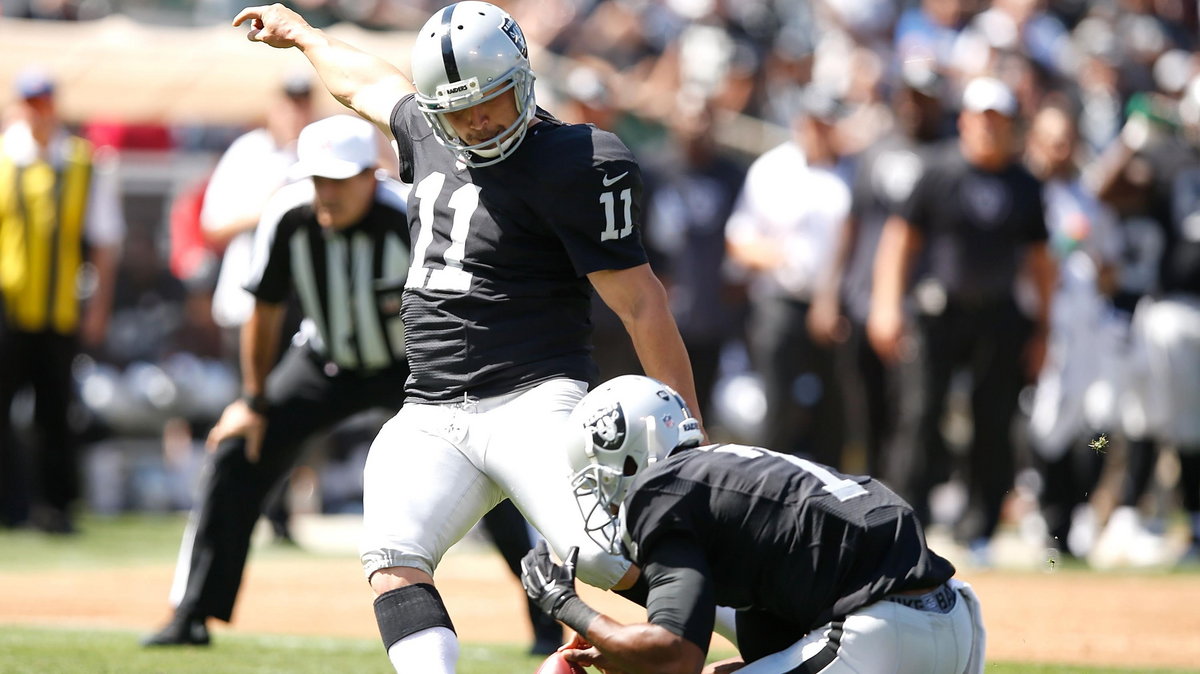 Sebastian Janikowski trafia w meczu z Baltimore Ravens.