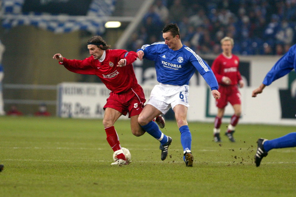 Kamil Kosowski w barwach Wisły Kraków walczy o piłkę z Tomaszem Hajtą w pamiętnym starciu z FC Schalke 04