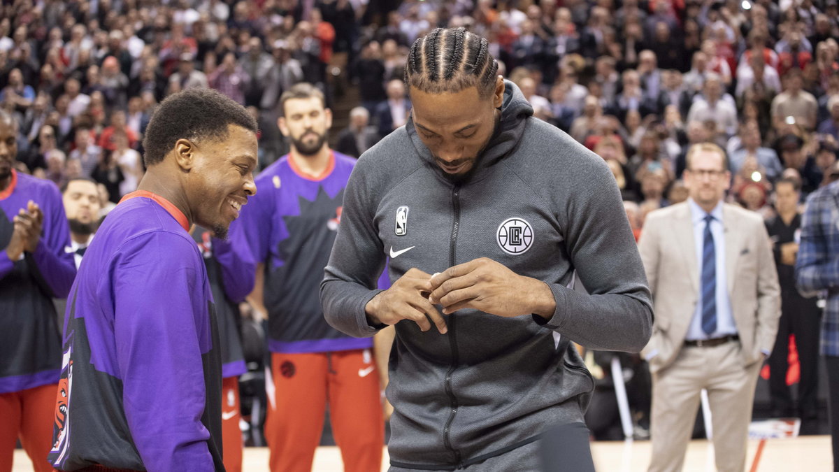 Kawhi Leonard (z prawej) zakładający na dłoń pierścień mistrzowski