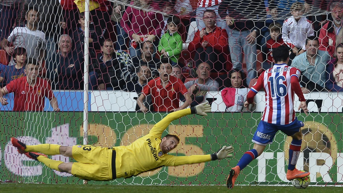 Sporting Gijon's forward Carlos Castro (R) kicks the ball next to Atletico Madrid's Slovenian goalkeeper Jan Oblak to score a goal during the Spanish league football match Real Sporting de Gijon vs Club Atletico de Madrid at El Molinon stadium in Gijon on