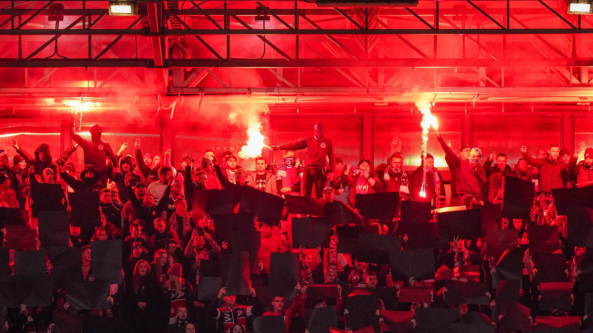 Kibice Wisły Kraków podpalający race na stadionie przy ul. Reymonta