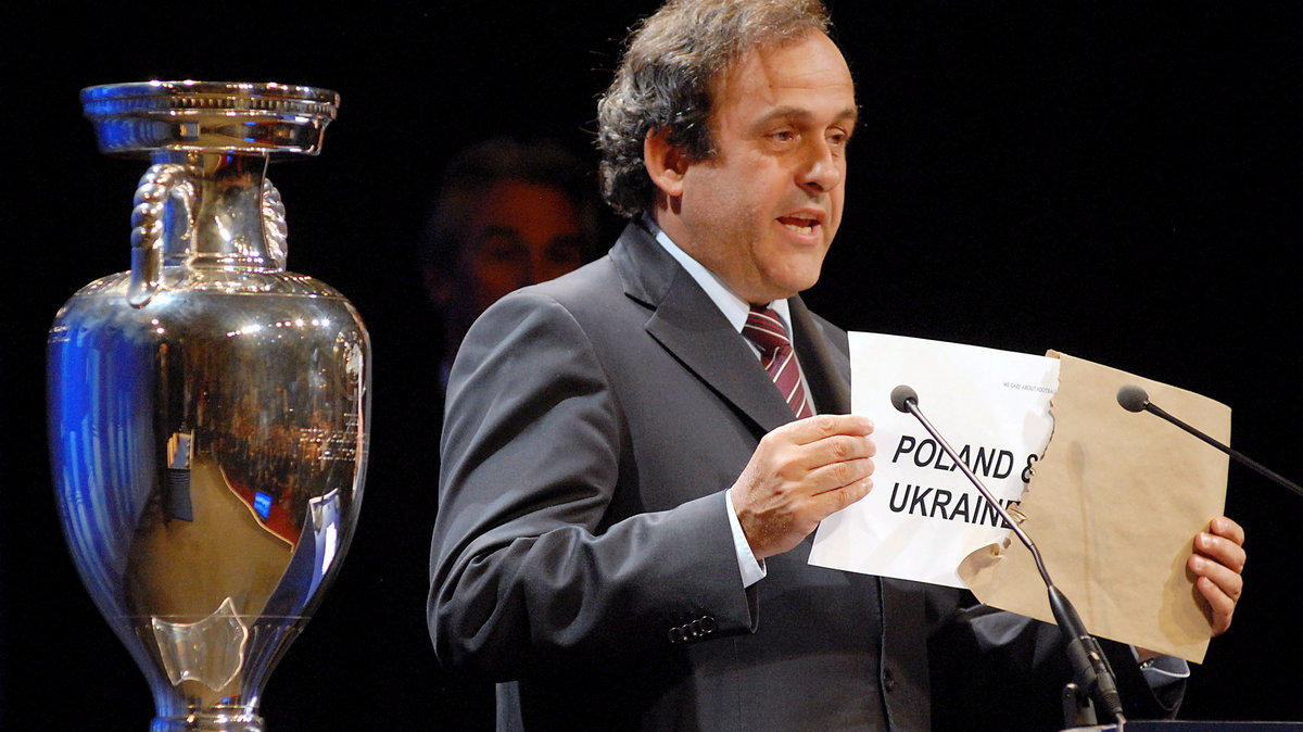 Michel Platini wyciąga kartkę z napisem "Polska i Ukraina"