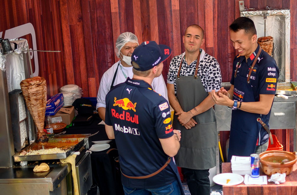 Kierowcy Red Bulla Max Verstappen (tyłem) i Alexander Albon mogli skosztować w padoku regionalnych tacos.