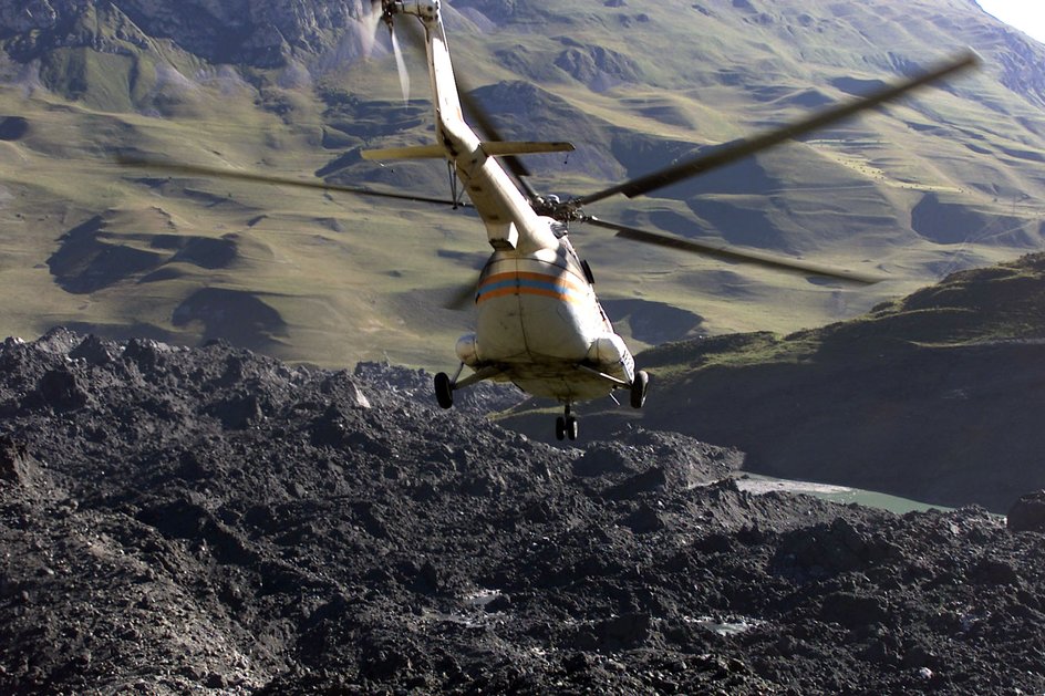 Ein Hubschrauber fliegt über den Ort, an dem die Lawine abging.