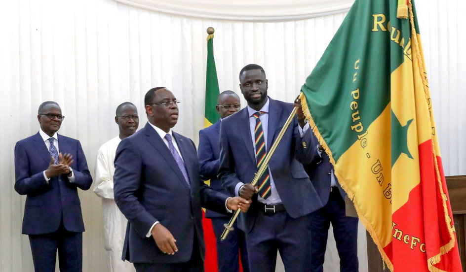 Kapitan reprezentacji z flagą Senegalu i prezydentem Mackym Sallem