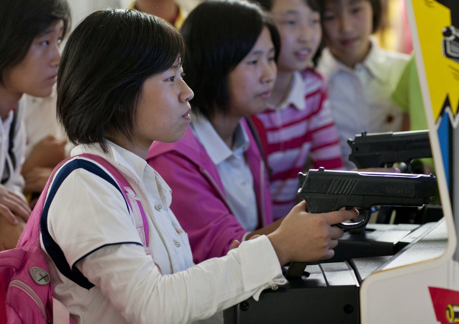 Północnokoreańskie dziewczynki grające w grę wideo z bronią w parku rozrywki Kaesong w Pjongjangu