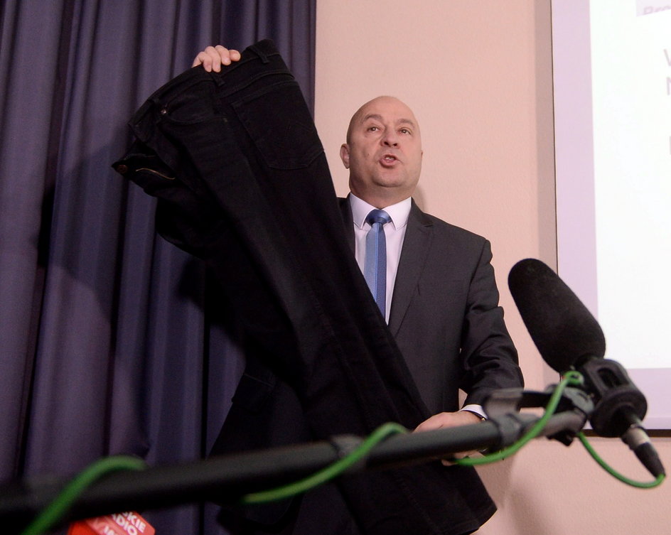 Kazimierz Greń prezentuje spodnie na konferencji prasowej