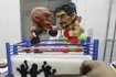 A cake decorator places details on a two-layer cake featuring fondant caricatures of boxers Manny Pacquiao (R) of the Philippines and Floyd Mayweather of the U.S. inside a boxing ring in Manila