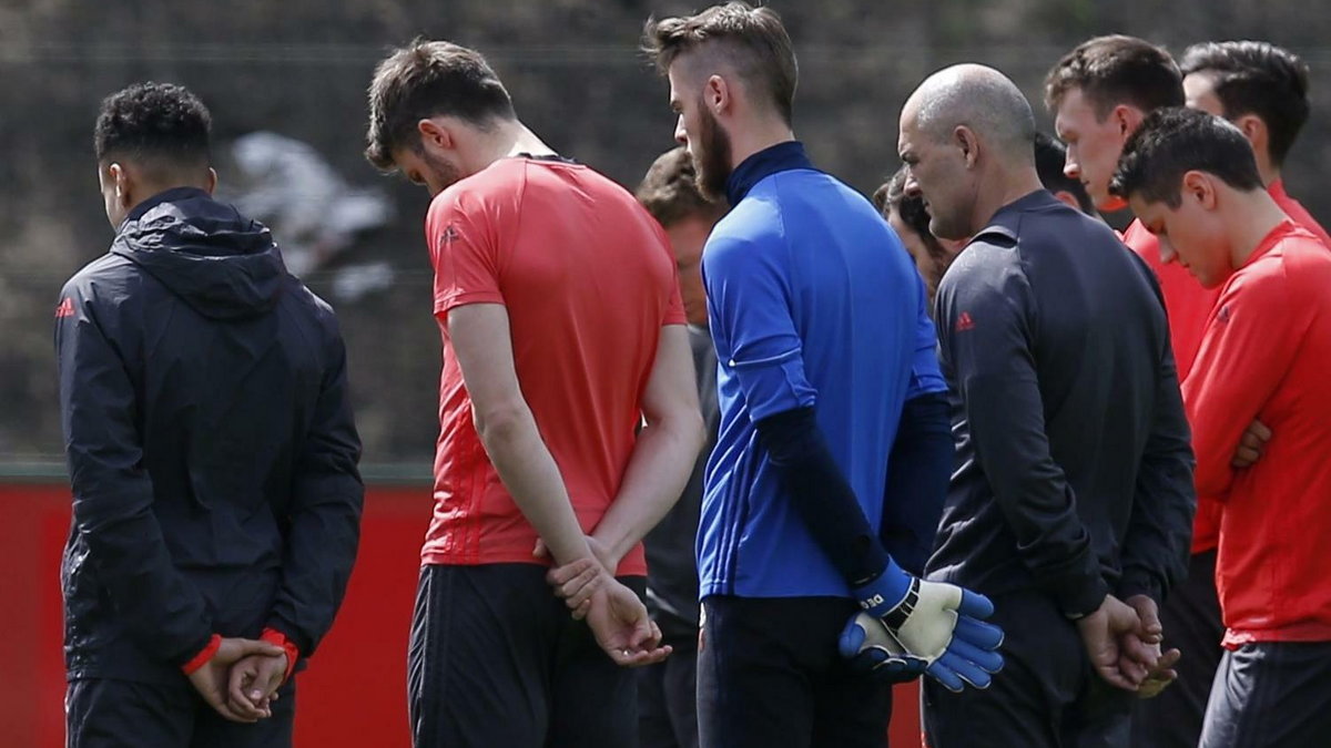 Manchester United players and staff stand for a minute of silence during training honouring the people killed and wounded in an explosion at Manchester Arena