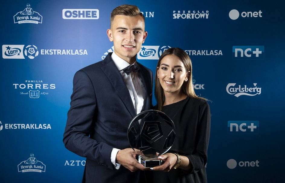 Michał Helik z narzeczoną Olą prezentuje nagrodę dla najlepszego obrońcy sezonu 2017/18.