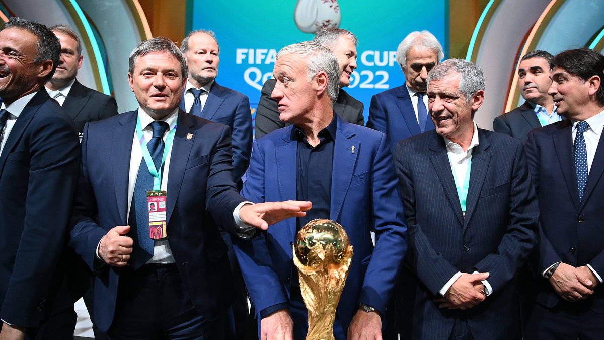 Trener Francji Didier Deschamps (w środku) i inni trenerzy pozują z trofeum mundialu podczas losowania grup mistrzostw świata 1 kwietnia 2022 r.