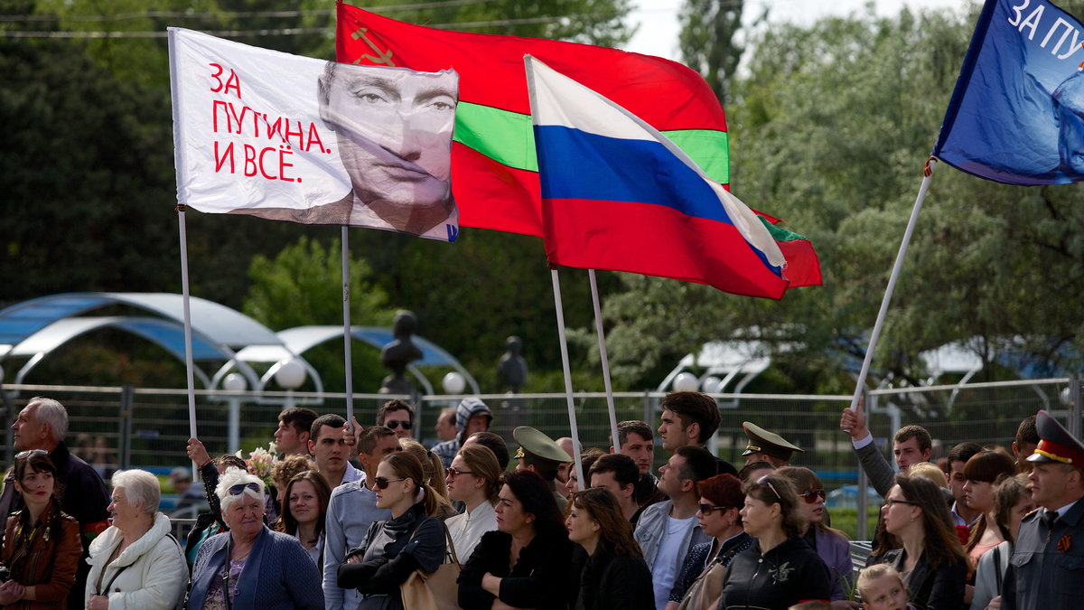 Mieszkańcy Tyraspola świętujący rosyjski Dzień Zwycięstwa. Na drzewcach flagi Naddniestrza, Rosji i podobizna Władimira Putina
