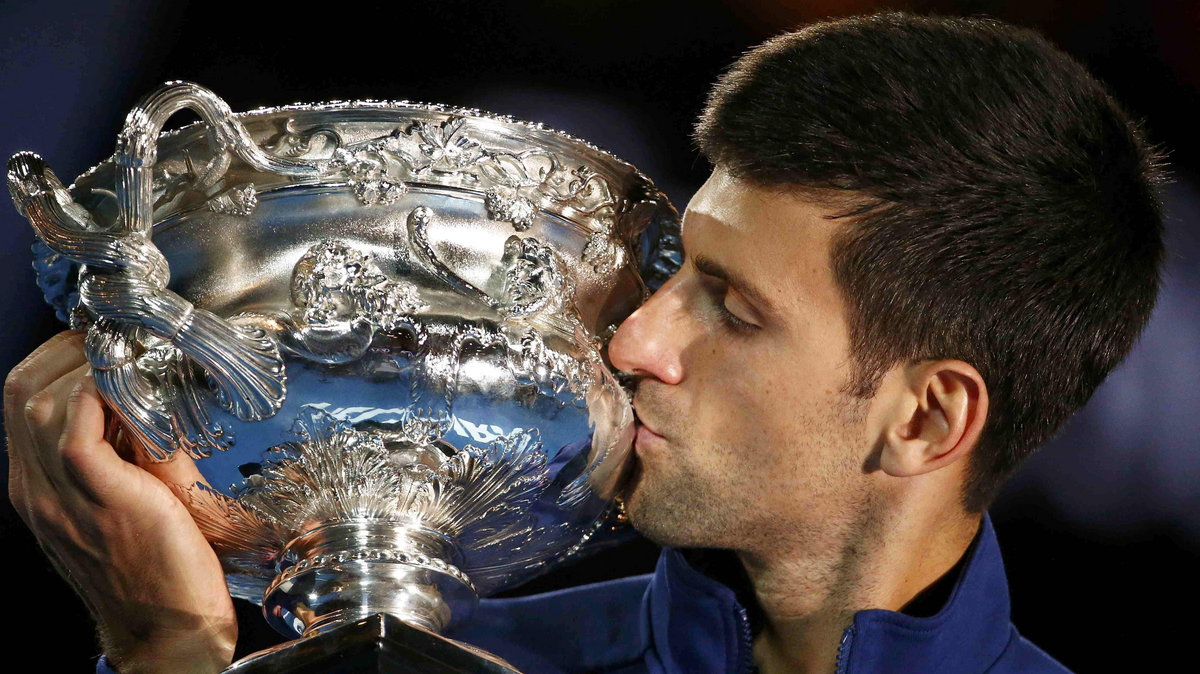 Serbia's Djokovic kisses the men's singles trophy after winning his final match against Britain's Murray at the Australian Open tennis tournament at Melbourne Park