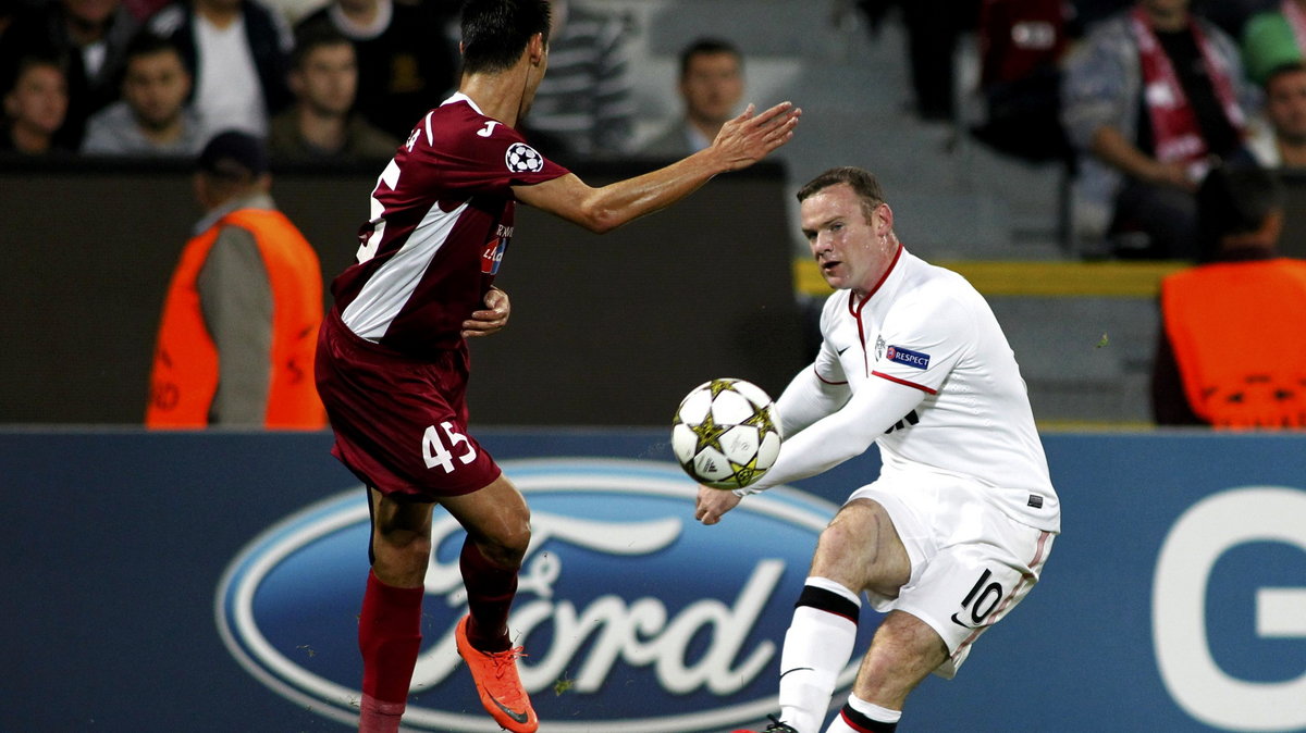 Manchester United's Rooney is challenged by CFR Cluj's Camora during their Champions League Group H soccer match in Cluj-Napoca