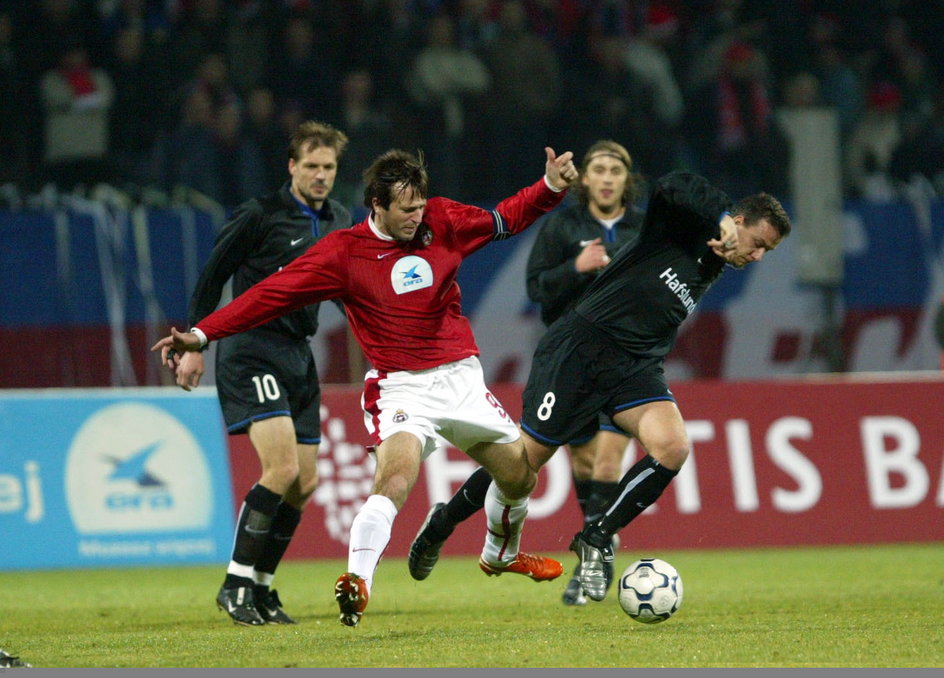 Maciej Żurawski rywalizuje z zawodnikami Valerengi Oslo podczas meczu Pucharu UEFA (27 listopada 2003 r.)