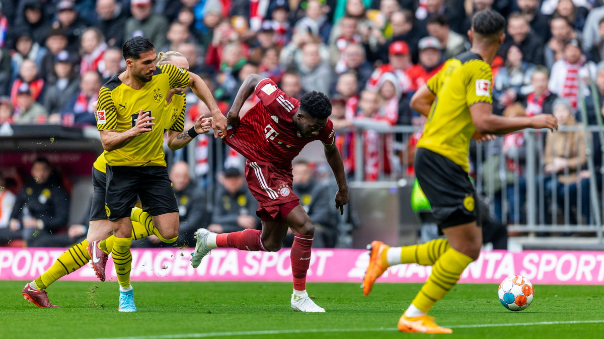 Alphonso Davies (w środku) w pojedynku z Emre Canem (L) w meczu Bayernu z Borussią Dortmund