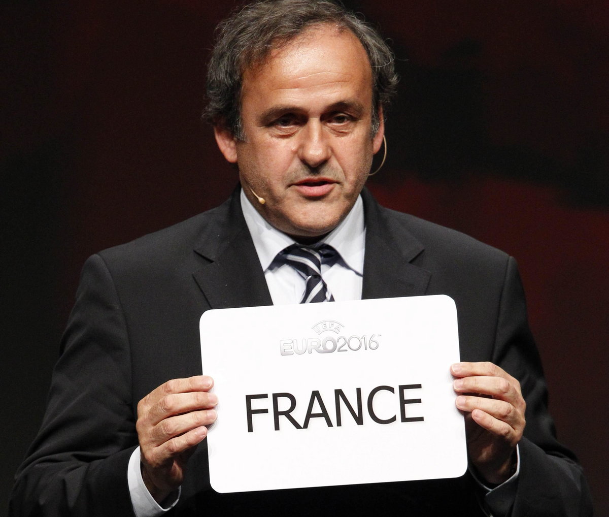 Michel Platini z kartką, która przedstawia państwo wybrane na gospodarza Euro 2016
